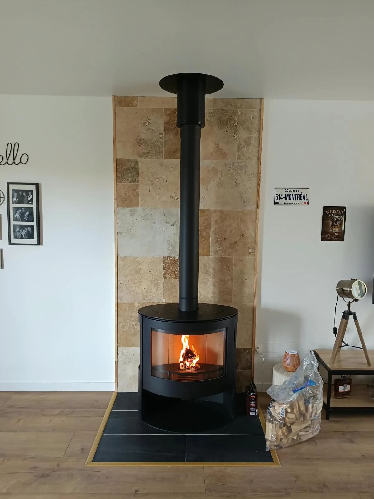 Poêle à bois cylindrique noir en fonctionnement dans un salon