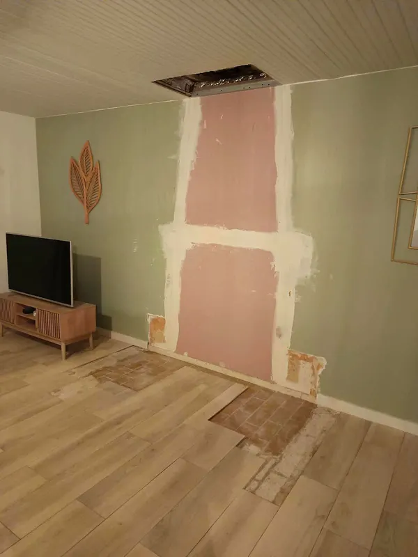 Mur refait : Plâtre repris, sol dégagé pour la plaque de sol.