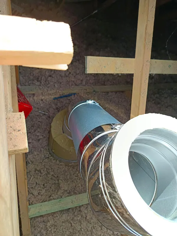 Conduit isolé en cours de pose dans les combles