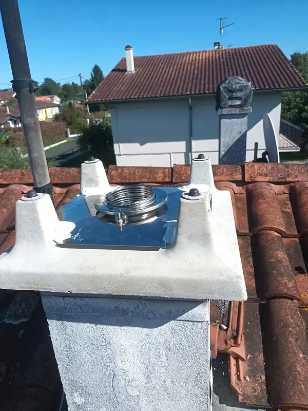 Solin d’étanchéité et départ de conduit inox sur une souche, toiture en tuiles